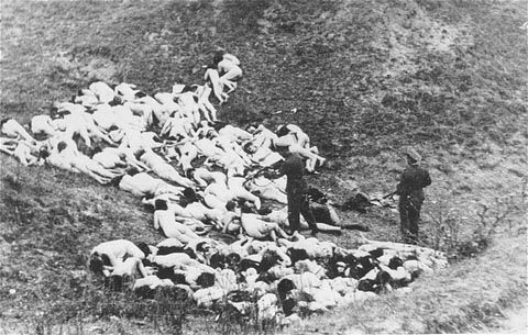 A German police officer shoots Jewish women still alive after a mass execution of Jews from the Mizocz ghetto